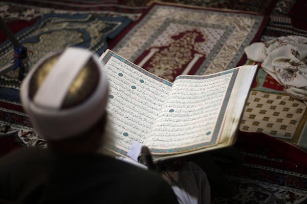 An elderly man reads verses of the Quran, Islam's holy book, on the first day of the fasting month of Ramadan in the grand Mosque in the old city of S