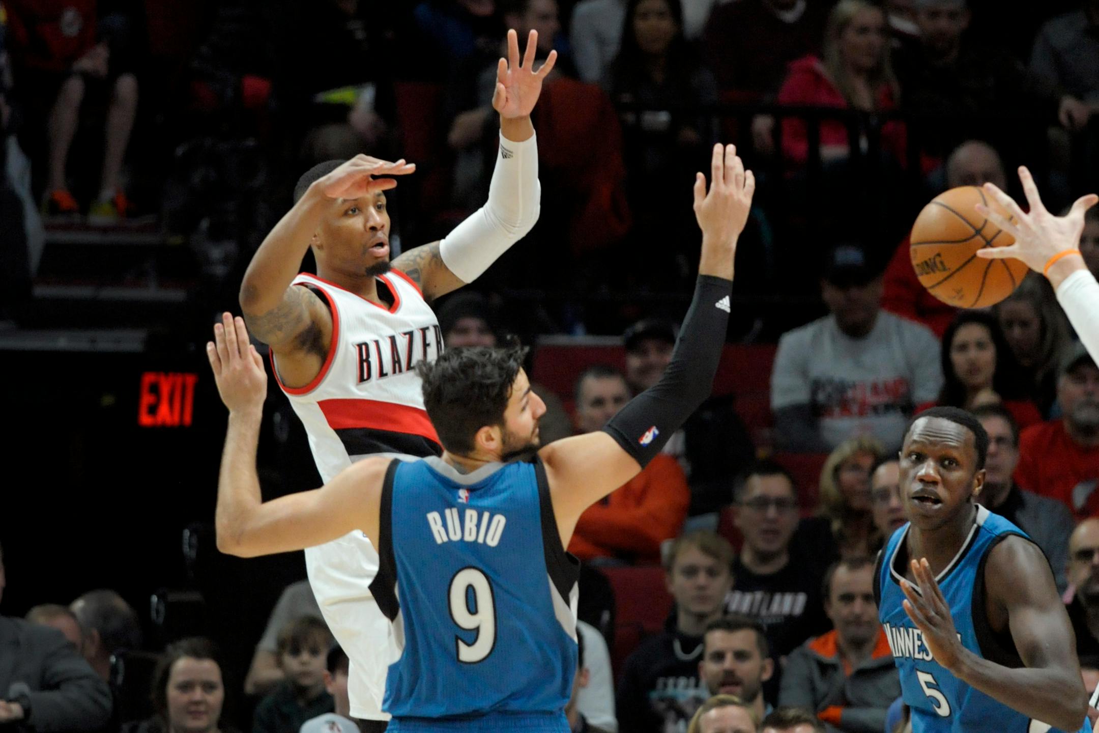Portland Trail Blazers guard Damian Lillard passes the ball over Minnesota Timberwolves guard Ricky Rubio during the first half of an NBA basketball game in Portland, Ore., Saturday, March 25, 2017. (AP Photo/Steve Dykes)