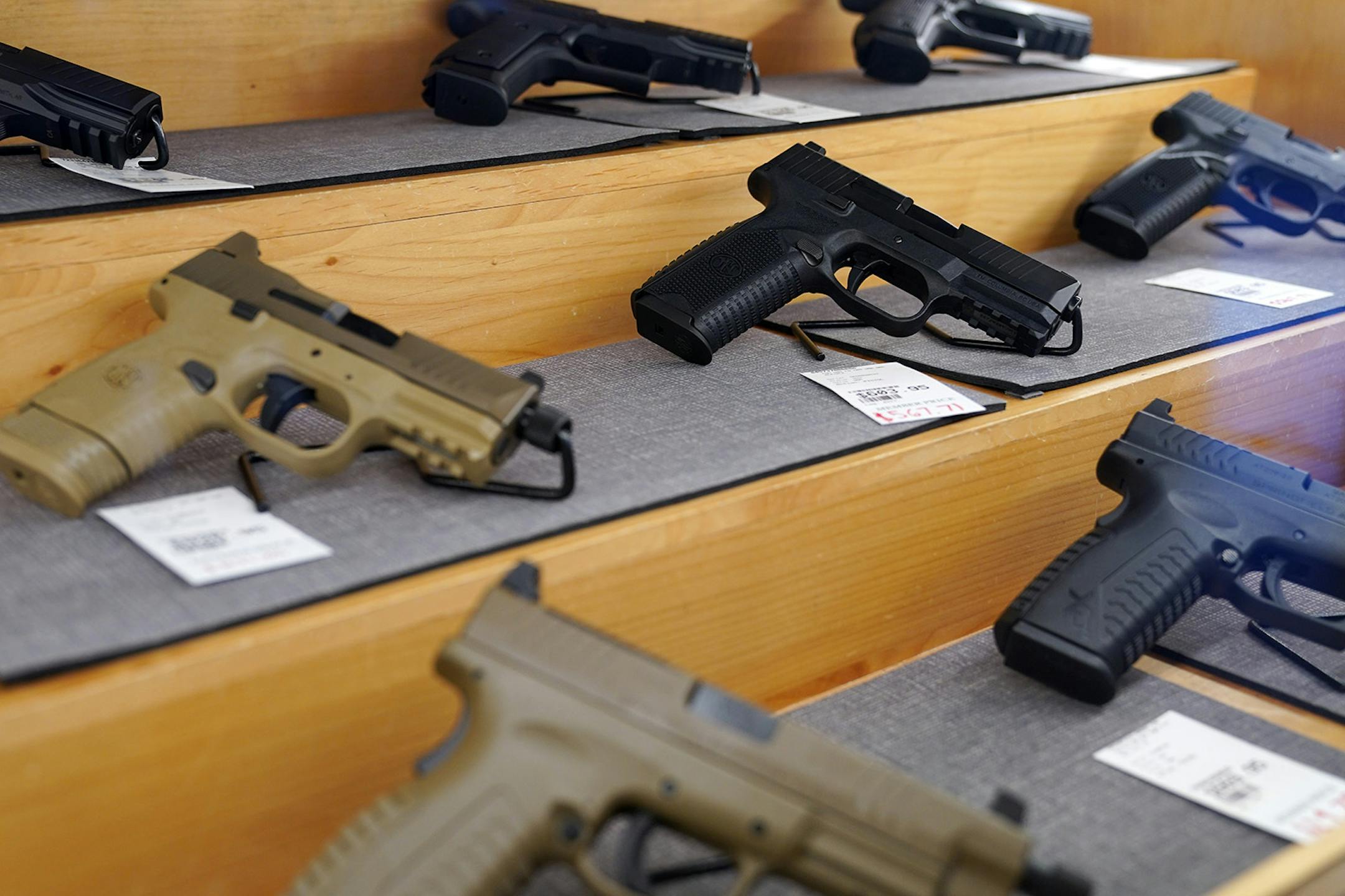 Handguns for sale behind glass in cases at the Stock & Barrel Gun Club.