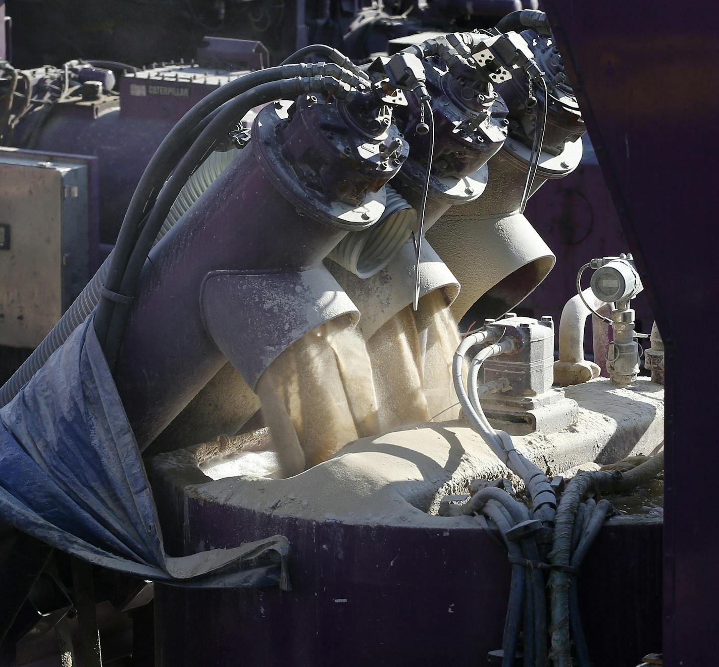 In this March 25, 2014 photo, a machine mixes sand and water, left, before it is pumped underground during a hydraulic fracturing operation at an Encana Corp. well pad near Mead, Colo. Hydraulic fracturing, or "fracking,"is the practice of injecting water, sand and chemicals into source rock to crack it and create escape routes for oil and gas. (AP Photo/Brennan Linsley)