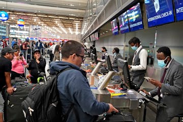 Delta ticketing agent Mohamed Abdi, right, helped a passenger check in at MSP’s Terminal 1 on Friday.