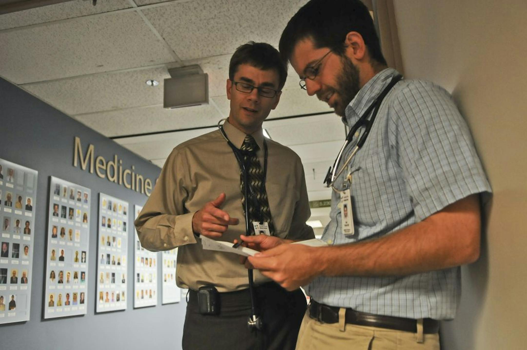 Dr. David Hilden, left, who burned out as a family physician, now practices at Hennepin County Medical Center. He talked to Dr. Dan Fulton, a third-year resident who is chipping away at about $173,000 of debt.