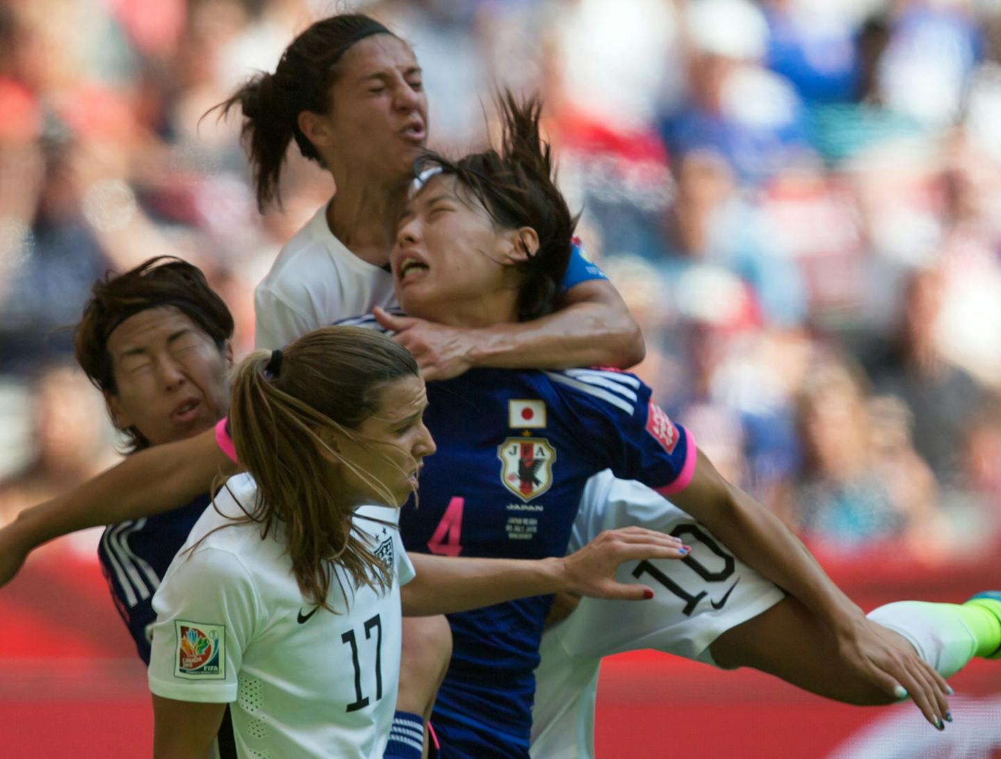 United States' Carli Lloyd, top, collides with Japan's Saki Kumagai (4) during the first half of the FIFA Women's World Cup soccer championship in Vancouver, British Columbia, Canada, on Sunday, July 5, 2015. (Darryl Dyck/The Canadian Press via AP) MANDATORY CREDIT