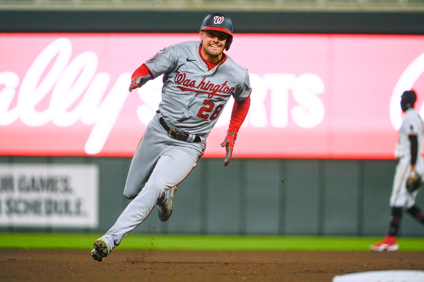 Washington's Lane Thomas rounds third base and heads home to score on a single hit by Keibert Ruiz during the eighth inning Friday night at Target Field.