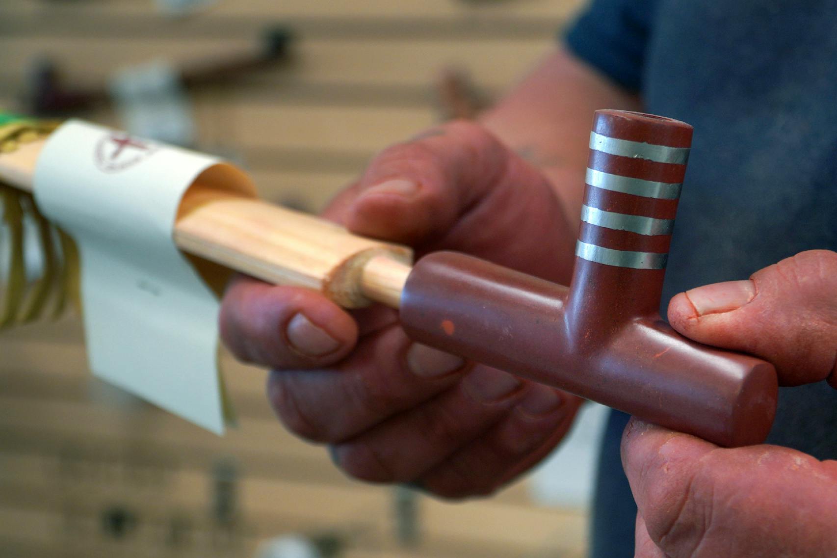 Travis Erickson holds a handmade pipe that he carved and crafted from pipestone.