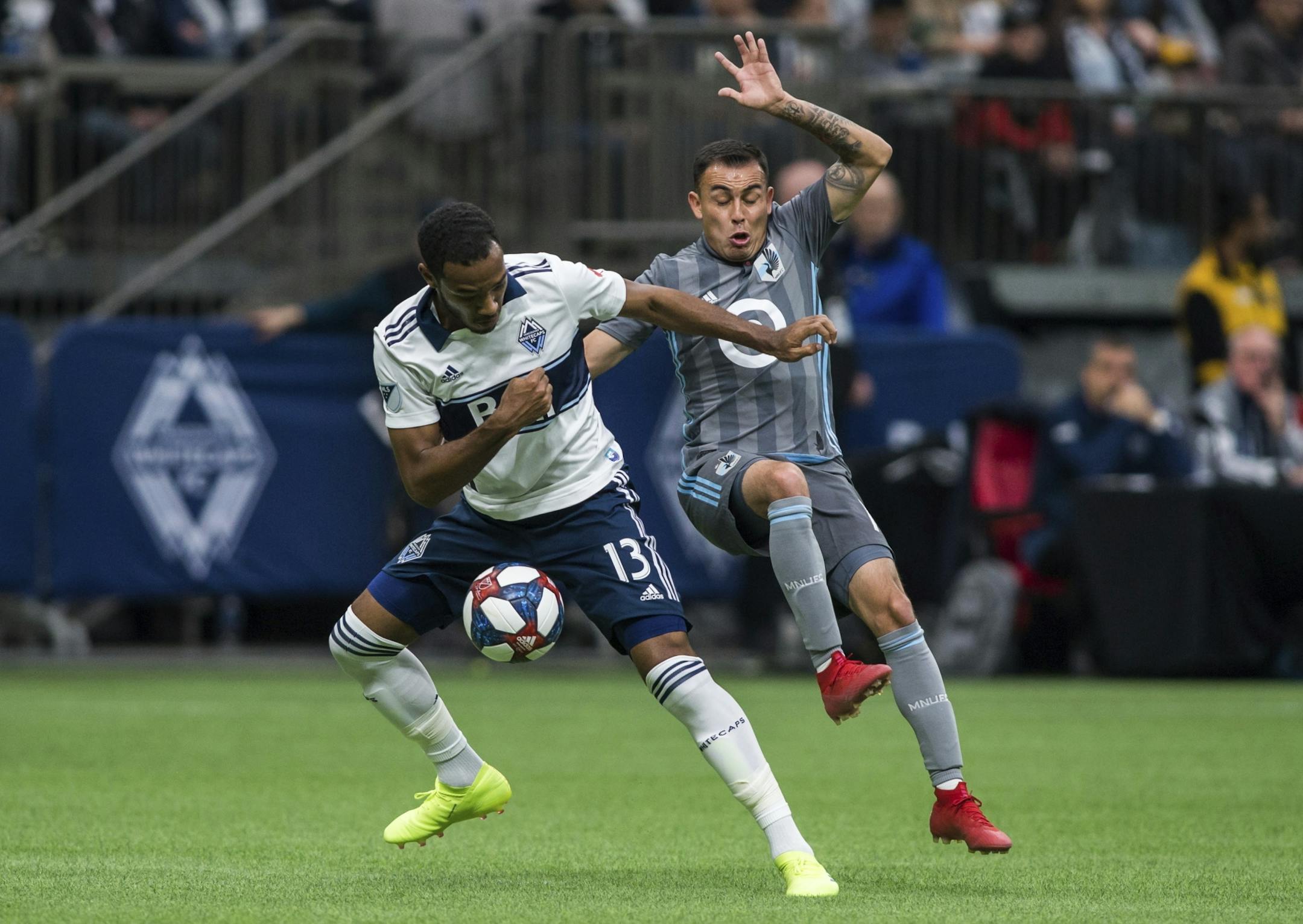 Vancouver Whitecaps' Derek Cornelius (13) plays the ball against Minnesota United's Miguel Ibarra during the first half of an MLS soccer match Saturday, March 2, 2019, in Vancouver, British Columbia.