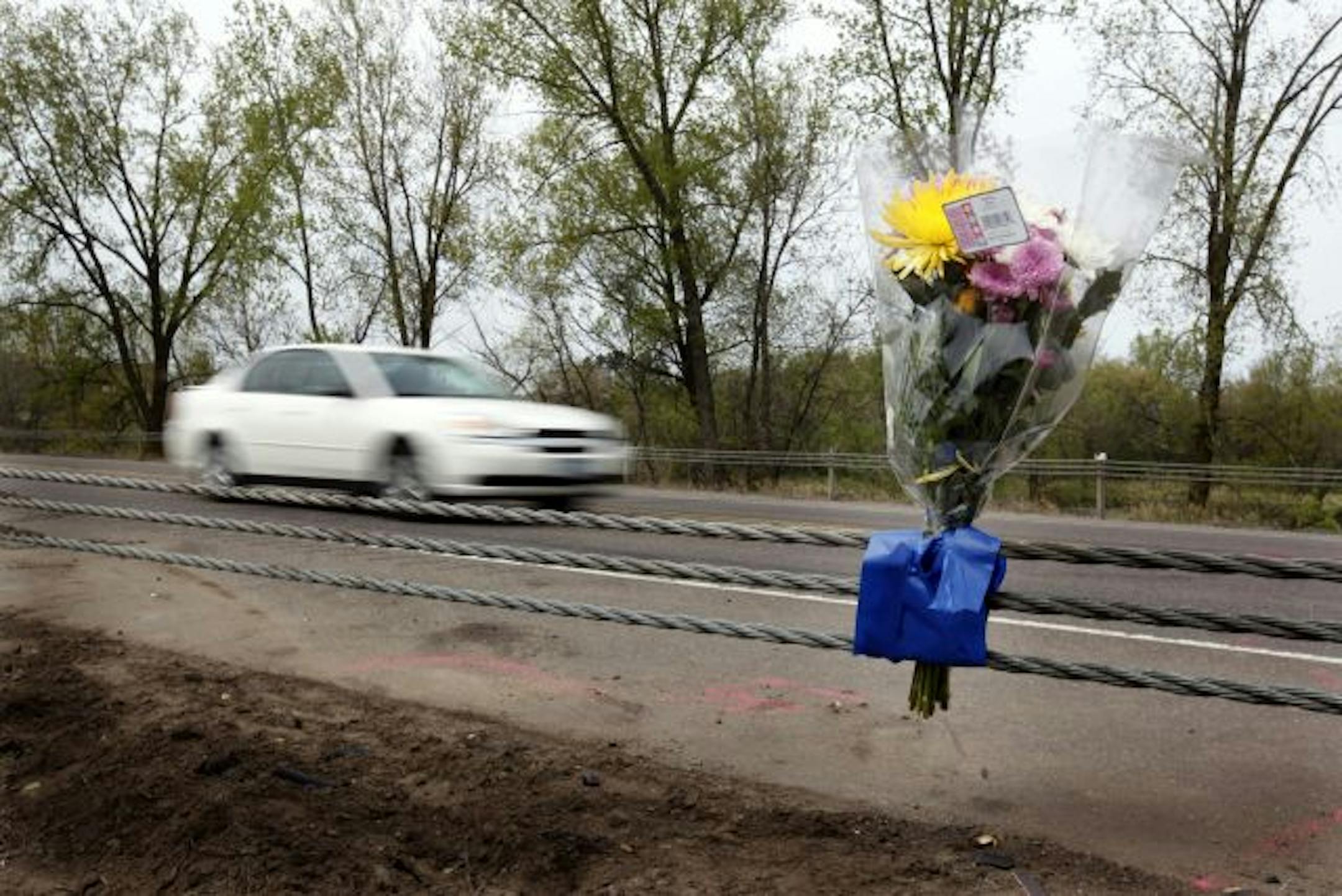 Flowers were placed on a guardrail at the scene of a car accident in Cambridge, Minnesota, Sunday, April 25, 2010. The crash killed four young people in a car that smelled of alcohol and two people in a charred SUV, the State Patrol said.