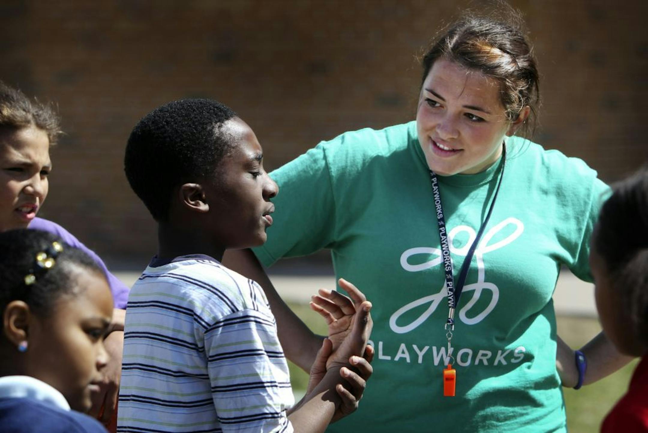 Playworks coach Samantha Weiss checked on fourth-grader Daniel Ajayi, who had hurt his wrist during recess.
