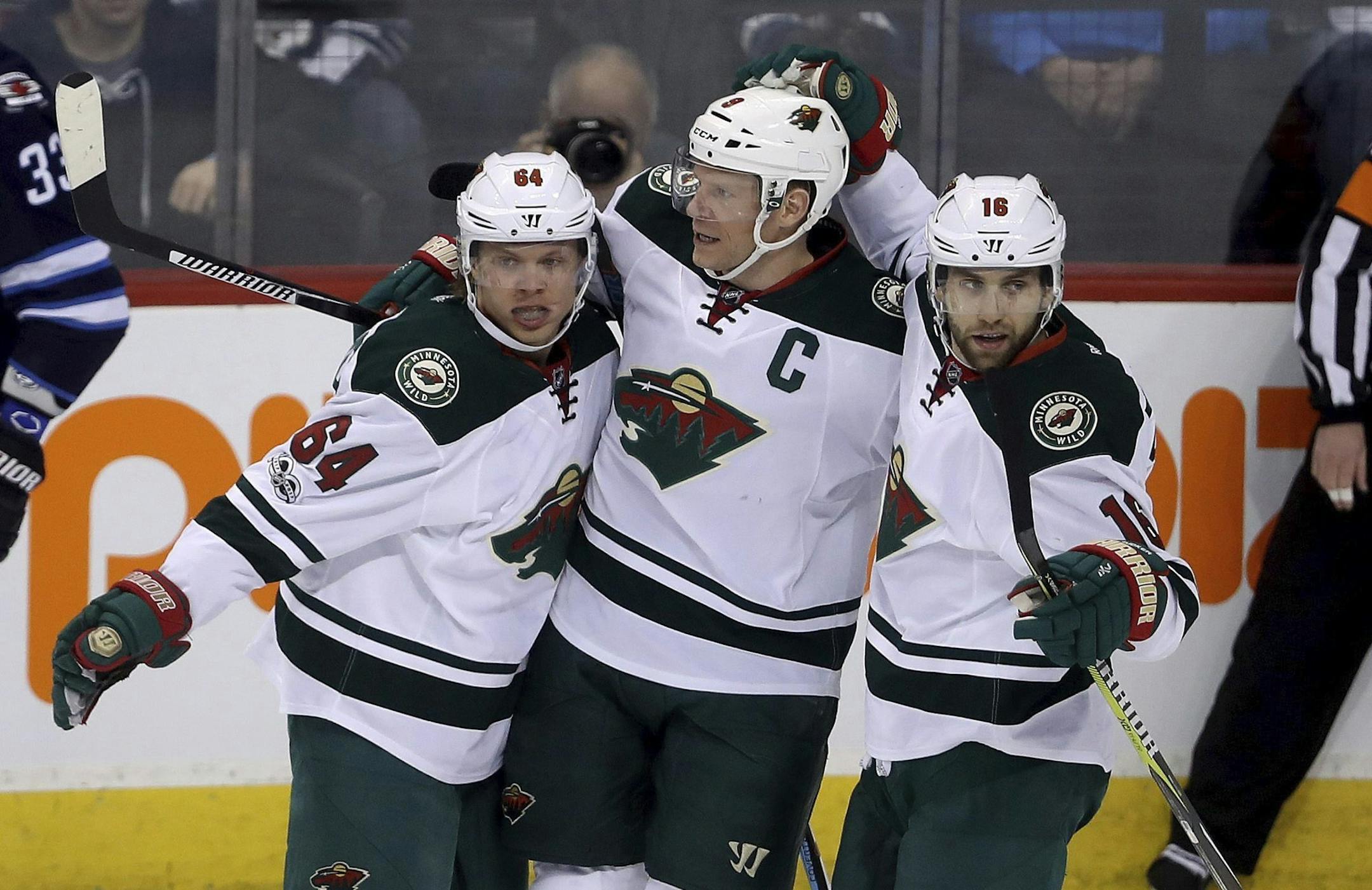 Minnesota Wild's Ryan Suter (20), Mikael Granlund (64), Mikko Koivu (9) and Jason Zucker (16) celebrate after Granlund scored, as Winnipeg Jets' Dustin Byfuglien (33) skates past during the first period of an NHL hockey game Tuesday, Feb. 28, 2017, in Winnipeg, Manitoba. (Trevor Hagan/The Canadian Press via AP) ORG XMIT: MIN2017022820324576