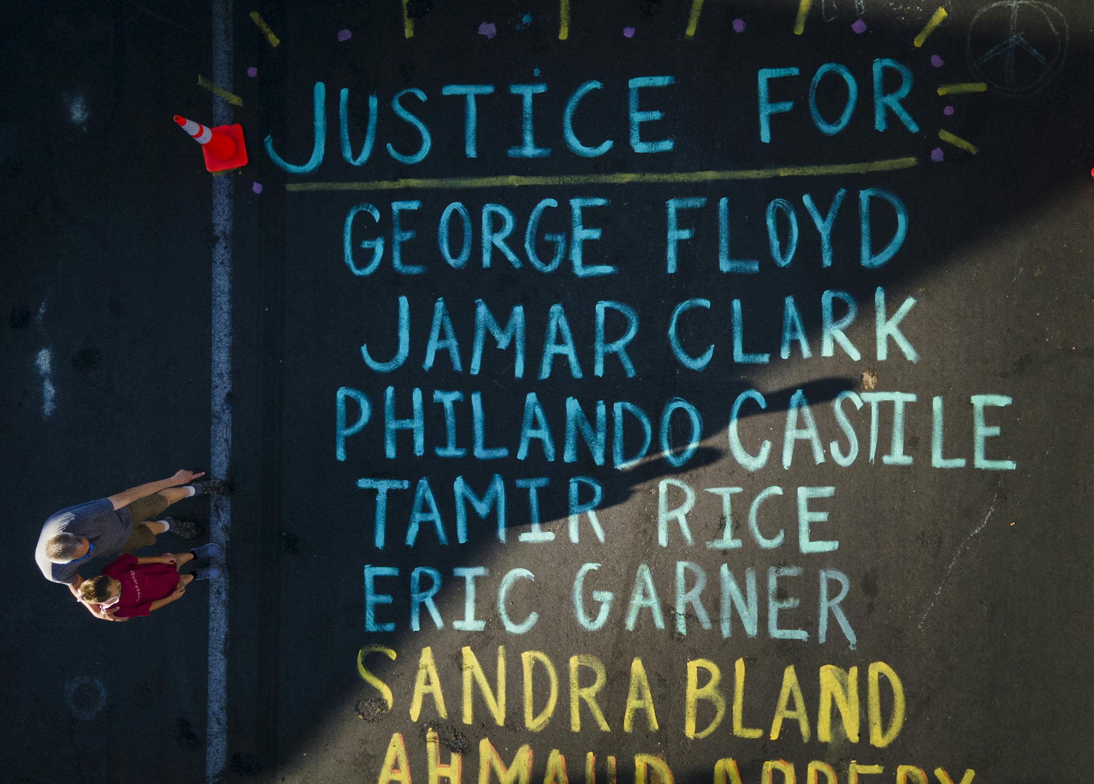 A man and child stopped to look at the names of people who activists say died as a result of racial injustice Tuesday morning on Chicago Avenue in south Minneapolis near where George Floyd died in police custody. ] aaron.lavinsky@startribune.com The memorial for George Floyd outside Cup Foods, where Floyd was killed last Monday night in the custody of Minneapolis Police, photographed Tuesday, June 2, 2020 in Minneapolis, Minn.