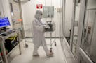 Workers like this one in the cleanroom at SkyWater Technology in Bloomington are in an environment that's much cleaner than a hospital surgical room.