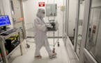 Workers like this one in the cleanroom at SkyWater Technology in Bloomington are in an environment that's much cleaner than a hospital surgical room.