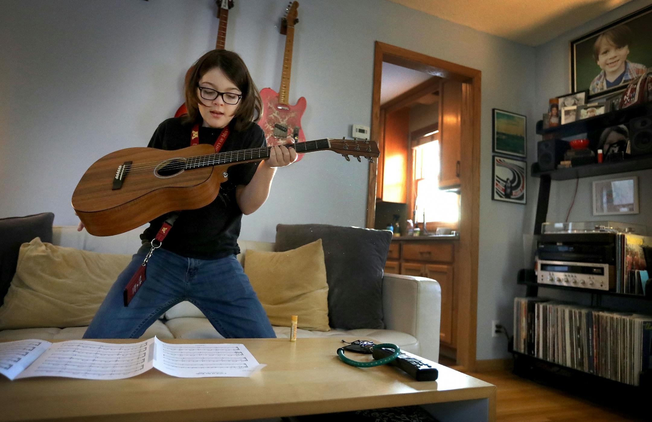 Elliott Tanner, 11, a junior at the University of Minnesota, plays guitar at his home before class.