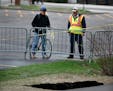 Authorities closed a 3/4-mile stretch of West River Parkway near Mill Ruins Park after a small sinkhole formed next to the bicycle path near Wednesday