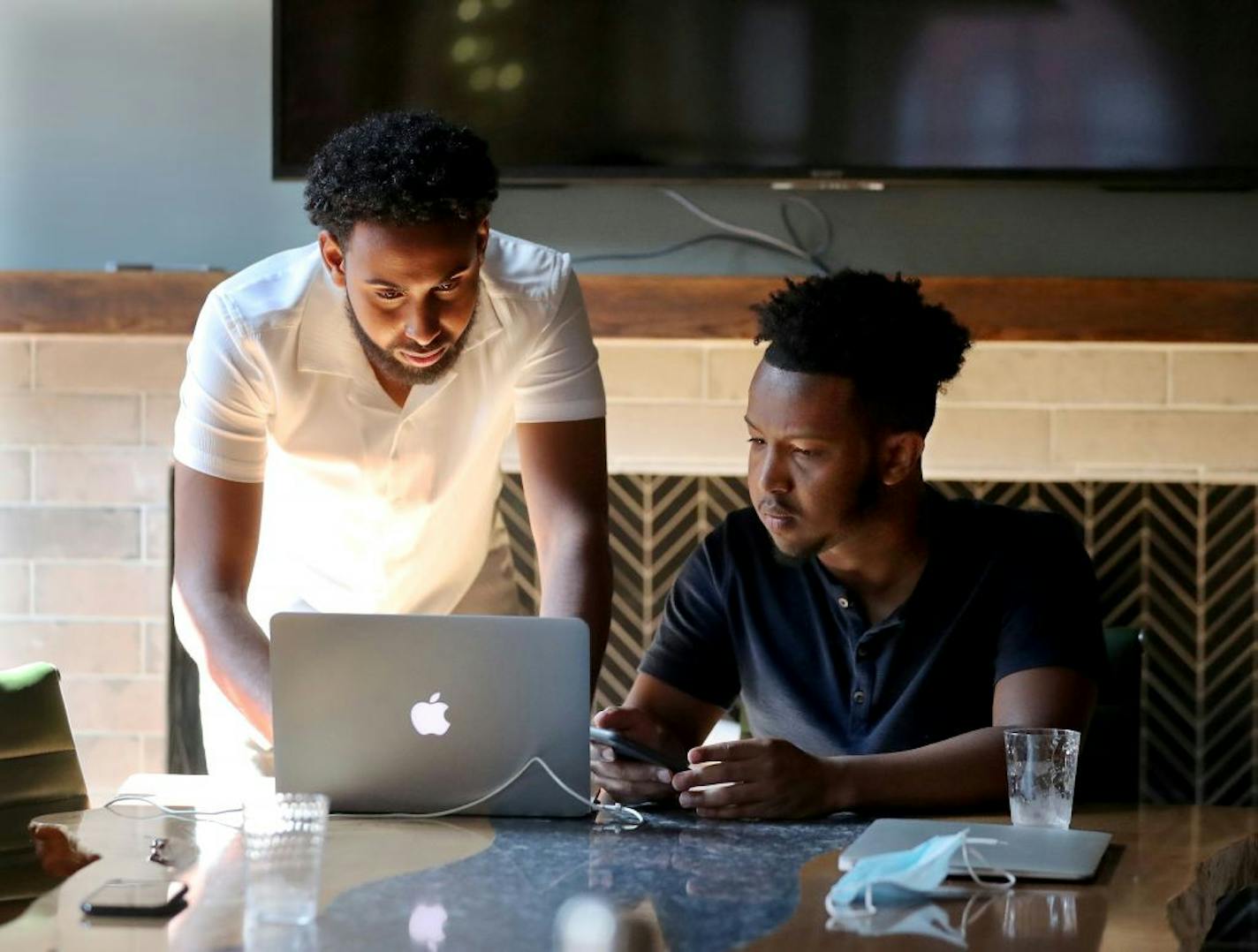 Entrepreneurs Abdi Hassan, 23, right, and Salman Elmi, 24, co founders of Top Figure were seen at Brick X Mortar, an exclusive, invite-only shared workspace and social club where they were preparing to tape an online tutorial for potential clients Friday in Minneapolis.