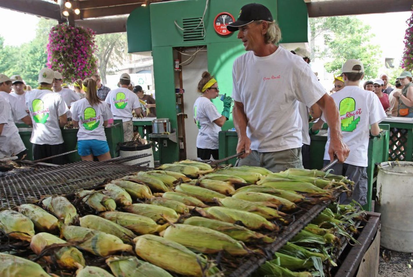 Brad Ribar, center, expects to peddle up to 190,000 ears of roasted corn from his spot near the fair's grandstand.