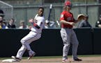 Minnesota Twins' Jorge Polanco, left, goes into third base ahead of the throw to Boston Red Sox's Brock Holt after hitting a triple off Red Sox pitche