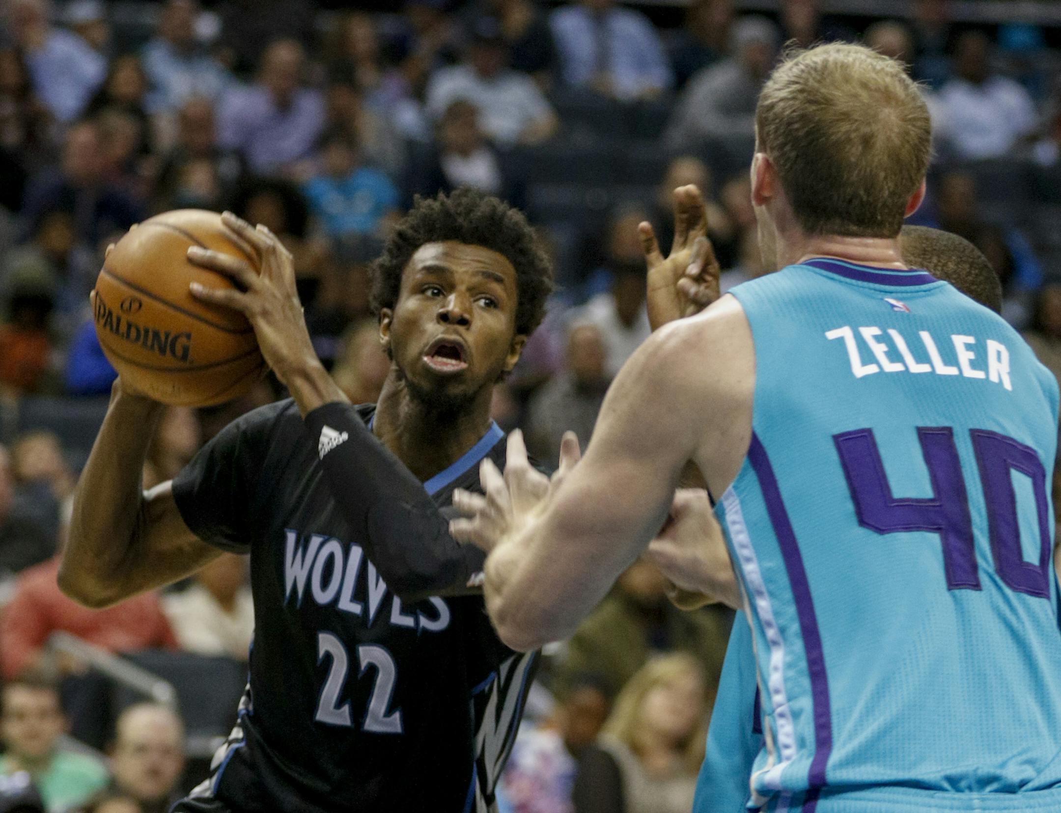 Minnesota Timberwolves forward Andrew Wiggins, left, looks to pass around Charlotte Hornets center Cody Zeller in the second half of an NBA basketball game in Charlotte, N.C., Saturday, Dec. 3, 2016. Minnesota won 125-120. (AP Photo/Nell Redmond)