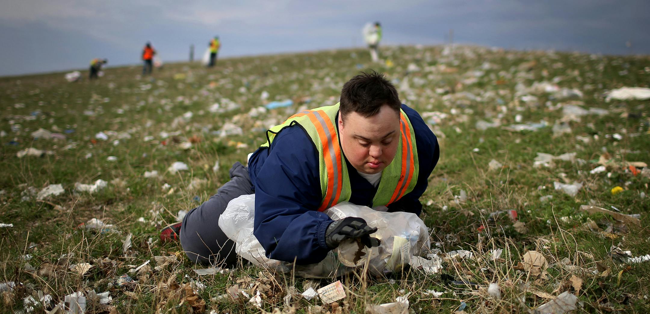 Scott Rhude, 33, sits spread-eagled in a field of garbage, reaching for a piece of trash while on a work assignment with a sheltered workshop "enclave" Tuesday, April 28, 2015, near the landfill in Wilmar, MN. Like many of his coworkers on the cleanup crew, Rhude dreams of landing a &#xec;real job&#xee; in the community. But for that, he would need specialized training, transportation to and from work and access to a job coach.&#xec;He is stuck, stuck stuck,&#xee; said Mary Rhude, Scott&#xed;s m