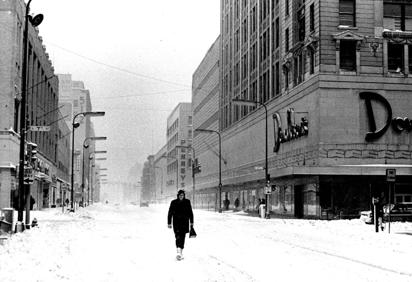 March 24, 1966 Downtown Minneapolis was nearly deserted .Wednesday during what is normally the rush hour after a spring blizzard left most area residents stranded in their homes. The lonely pedestrian with Nicollet Av. all to himself was Dave Scheusner, 4732 Pillsbury Av., who was en route to work, warmly shod in white Arctic boots. Nary a car challenged his right to the middle of the street. March 23, 1966 March 25, 1966 Dwight Miller, Minneapolis Star Tribune ORG XMIT: MIN2017012403374505