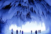 After trekking on frozen Lake Superior, visitors admire the striking Apostle Islands Ice Caves