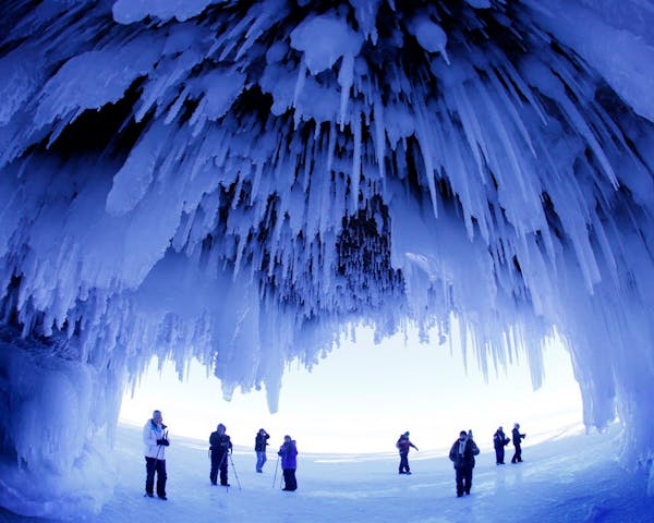 After trekking on frozen Lake Superior, visitors admire the striking Apostle Islands Ice Caves