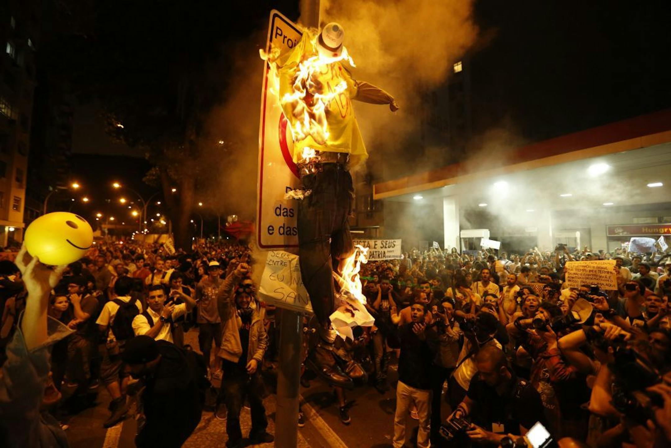 Protesters burn a puppet that symbolizes Rio de Janeiro State Governor Sergio Cabral during a demonstration near Guanabara Palace in Rio de Janeiro, Brazil, Monday, July 22, 2013. Police and anti-government protesters clashed outside the palace hosting Pope Francis welcoming ceremony.