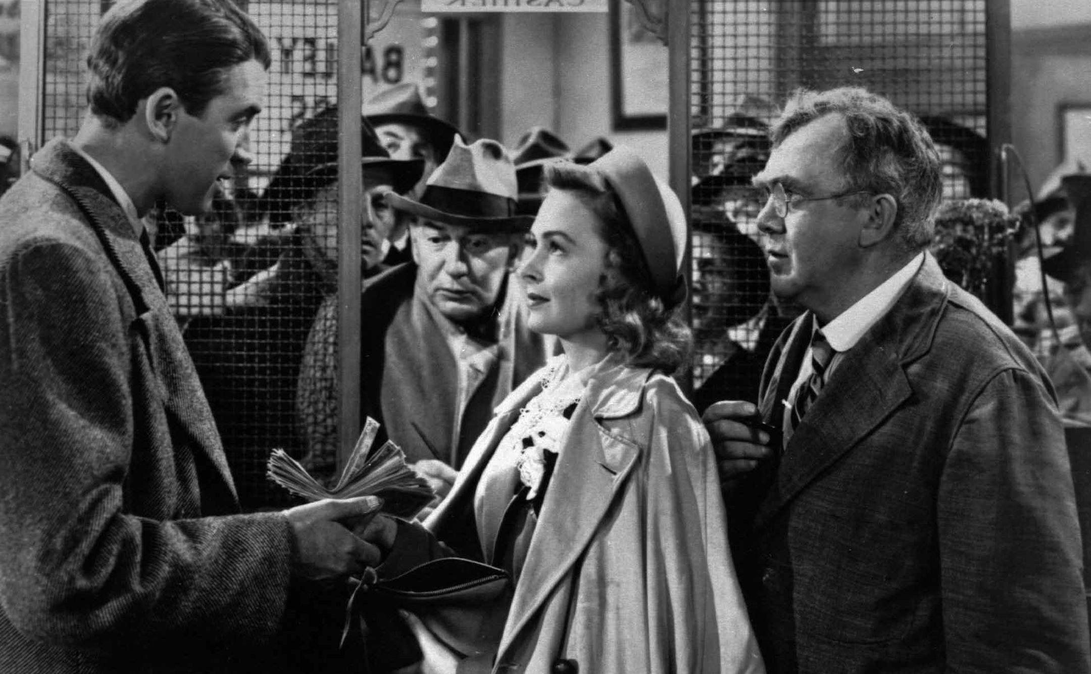 In this undated file photo James Stewart, left, Thomas Mitchell, right, and Donna Reed appear in a scene from the 1946 film "It's A Wonderful Life." Folks in Seneca Falls, N.Y., think Bailey's make-believe hometown, Bedford Falls in the movie, was heavily inspired by their quaint upstate town. This cannot be proven, and director Frank Capra never confirmed such a connection, but that hasn't stopped locals in Seneca Falls from celebrating the beloved movie every December. (AP Photo, File)