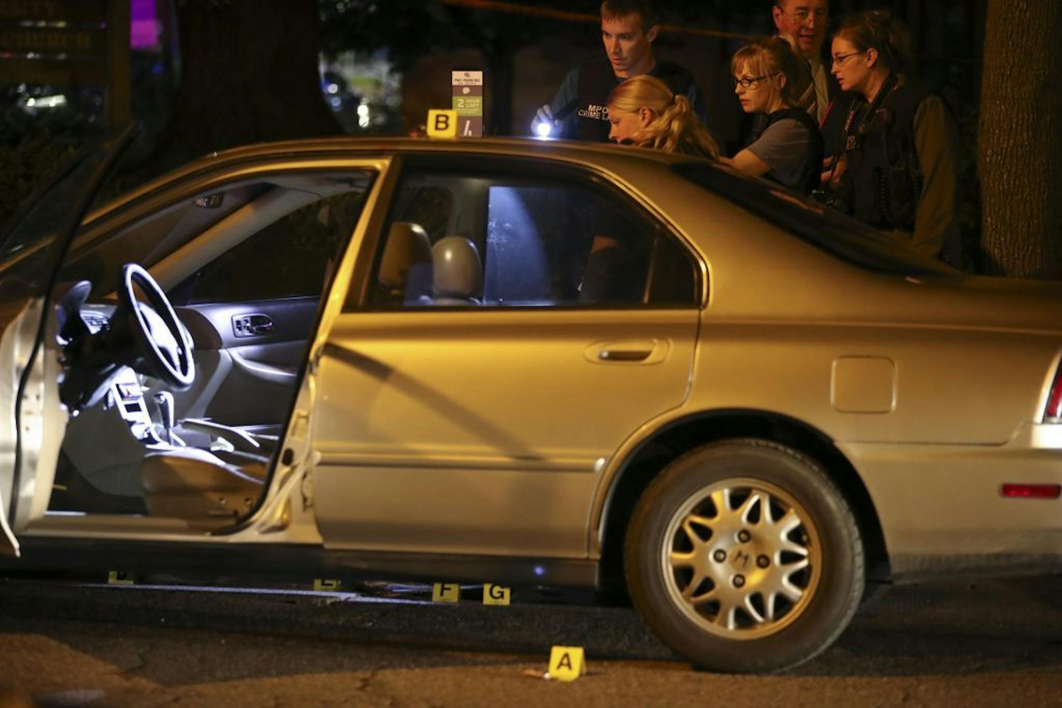 Investigators from the Minneapolis Police Department crime lab documented evidence around the car where a stabbing took place in Dinkytown Thursday night.