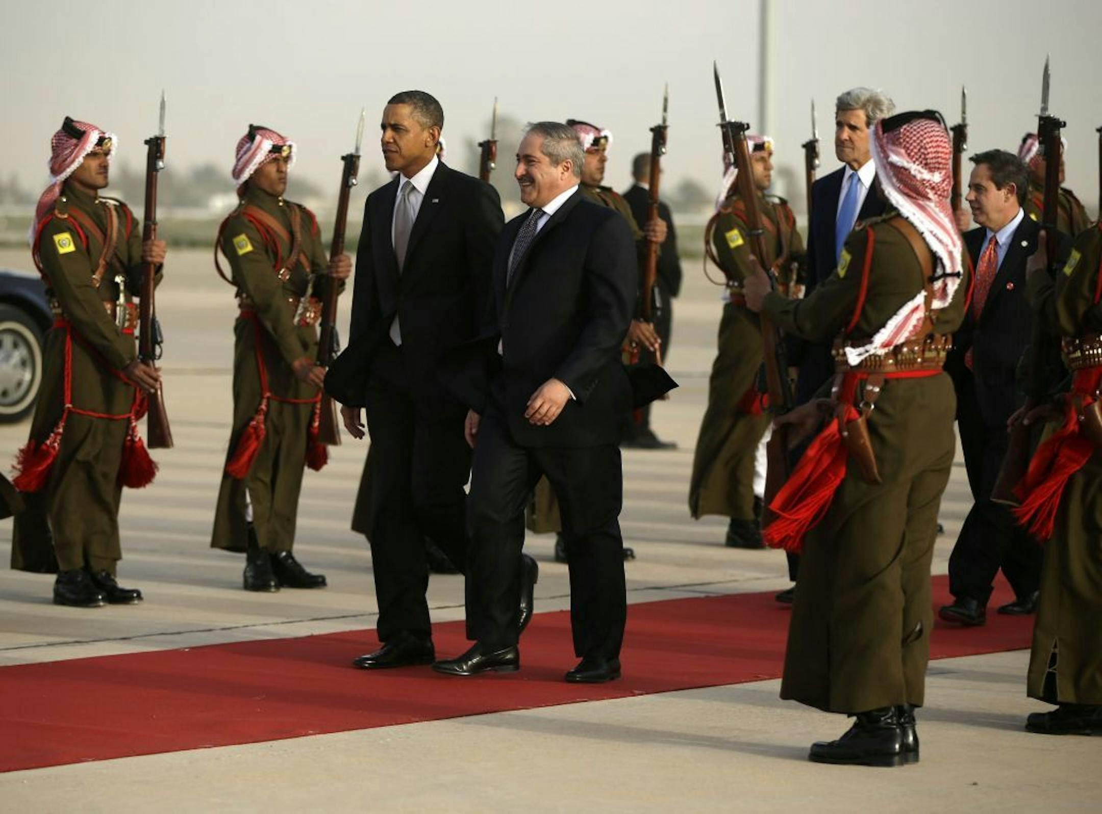 President Barack Obama walks with Jordanian Foreign Minister Nasser Judeh, right, upon his arrival at Queen Alia International Airport in Amman, Jordan, Friday, March 22, 2013. Secretary of State John Kerry and US Ambassador to Jordan Stuart Jones walk behind.