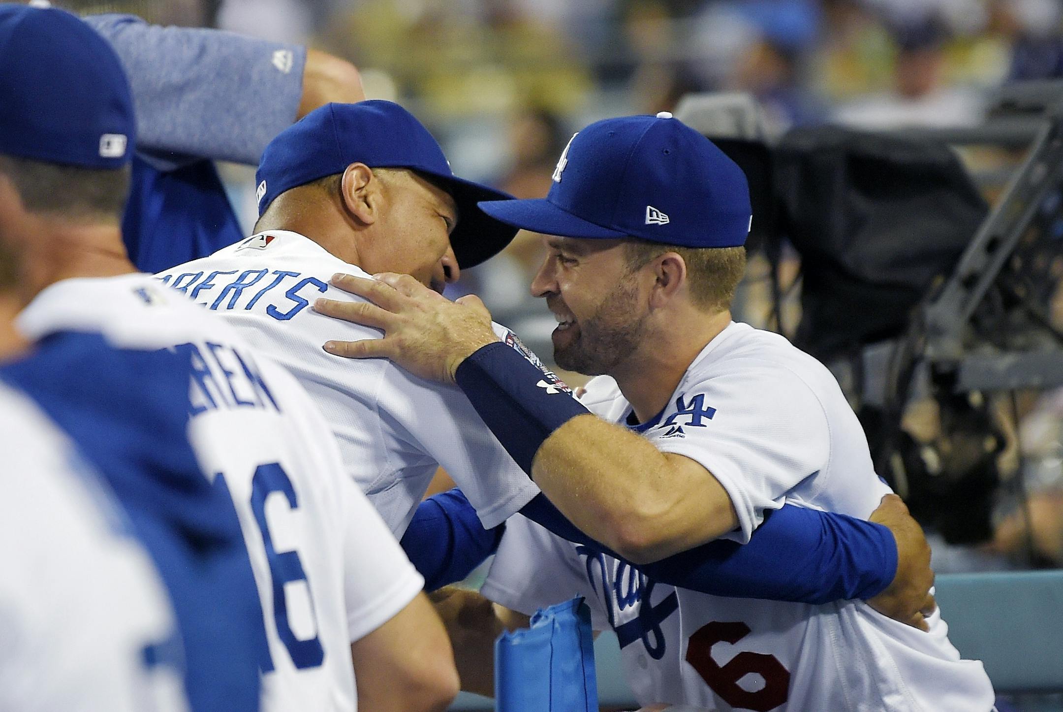 Los Angeles Dodgers manager Dave Roberts, left, greets Brian Dozier in the dugout during the ninth inning of the team's baseball game against the Milwaukee Brewers on Tuesday, July 31, 2018, in Los Angeles. Dozier was acquired by the Dodgers in a Tuesday trade with the Minnesota Twins.