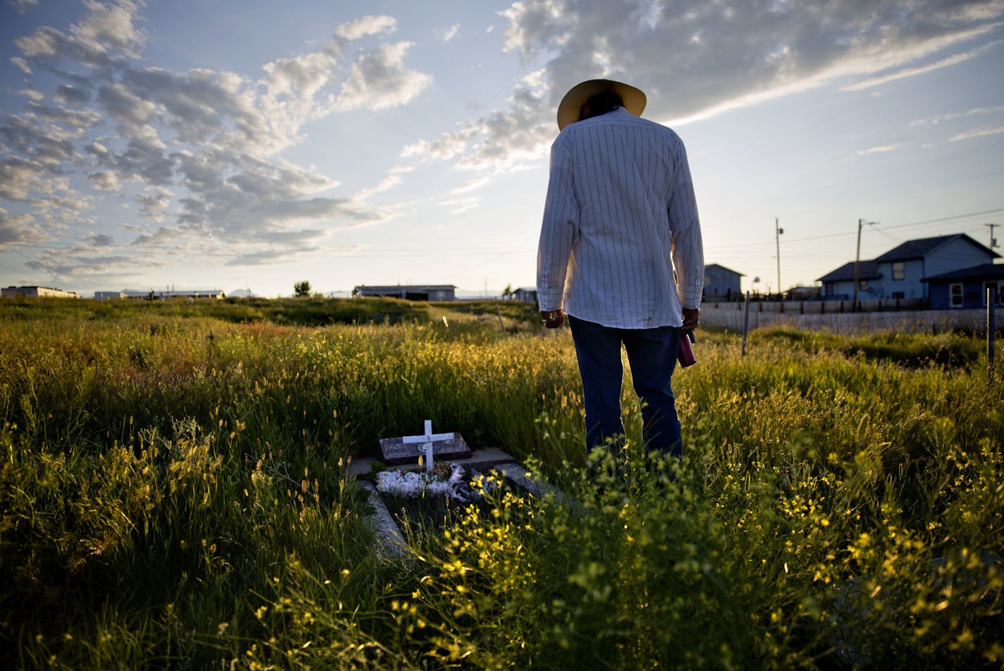 Kenny Still Smoking stands over the tombstone of his 7-year-old daughter, Monica, who was disappeared from school in 1979 and found frozen on a mountain, as he visits her grave on the Blackfeet Indian Reservation in Browning, Mont., Saturday, July 14, 2018. "I talk to her, let her know I'm doing ok, that I'm still kicking," he said. "I think about her all the time." (AP Photo/David Goldman)