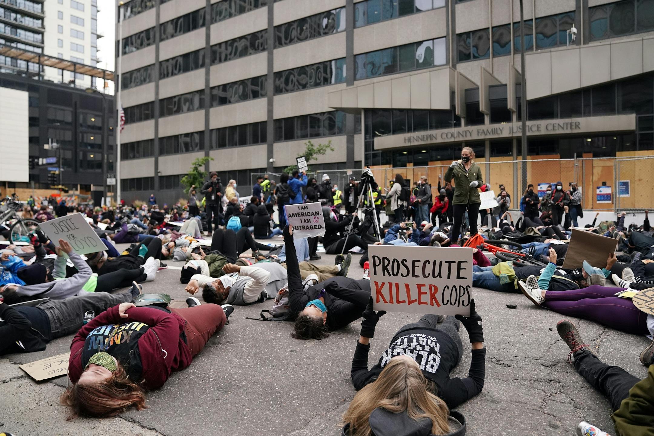 Protesters staged a die-in outside the Hennepin County Family Justice Center as family and defendants arrived for Friday's hearing.