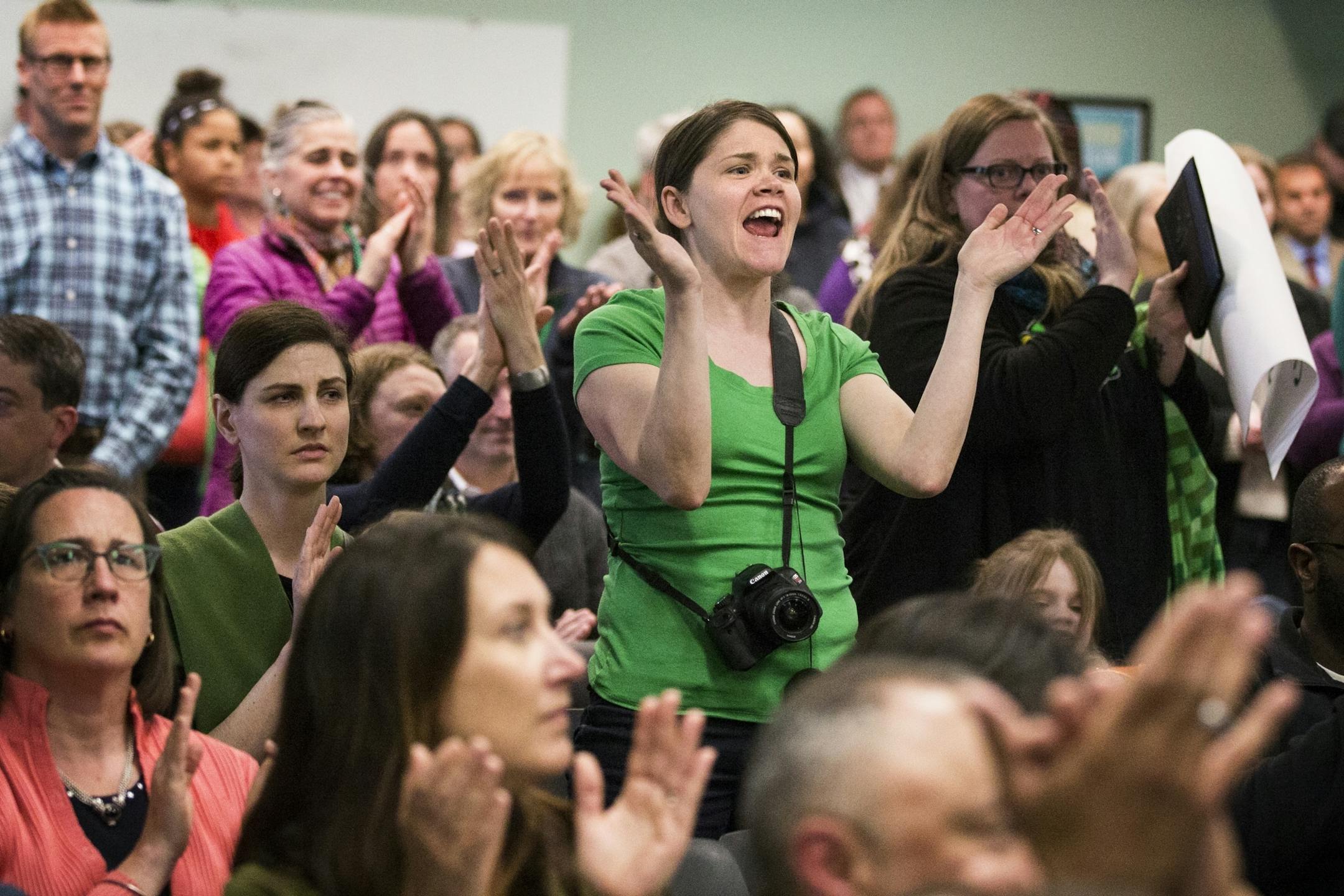 Mara Martinson, the parent of a Galtier Community School student, cheers during the public comment portion of a St. Paul School Board meeting.