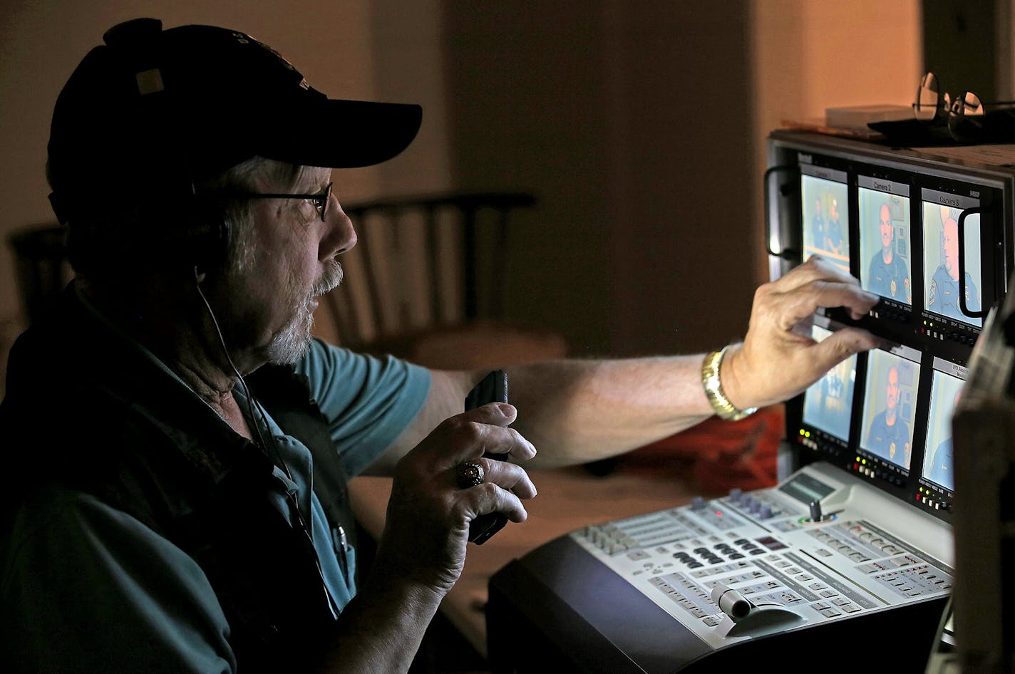 Mark Moore, cable coordinator, used a cell phone light to help tape a police informational show, Wednesday, July 22, 2015 in Apple Valley, MN. Farmington Police are joining Apple Valley and Rosemount in producing a local television show about policing and public safety issues.