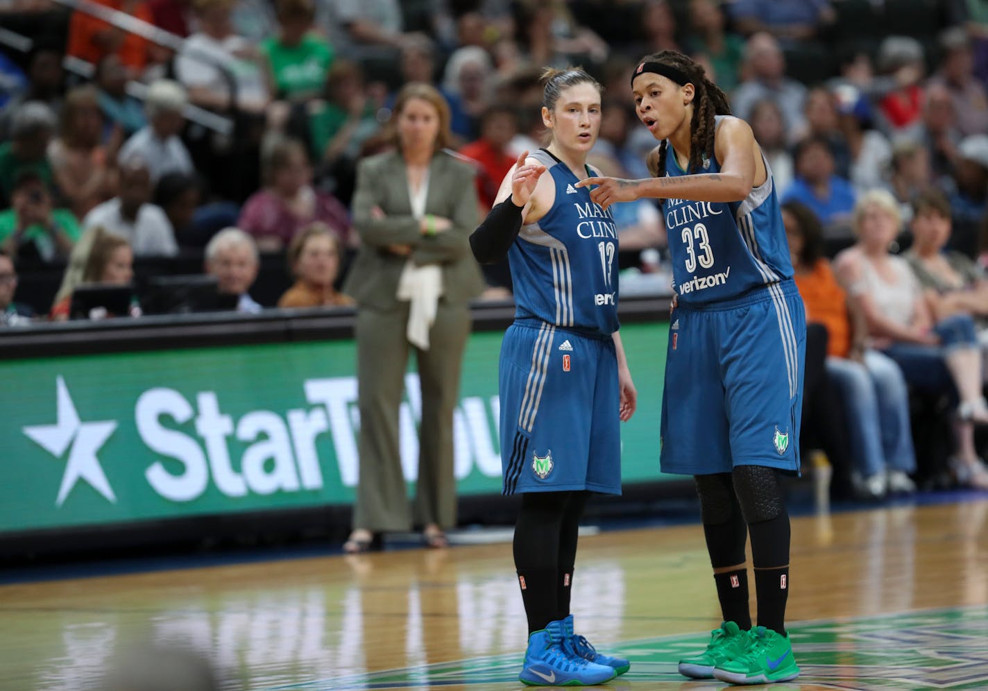 Minnesota Lynx guard Lindsay Whalen (13) and forward Seimone Augustus (33) confer while a teammate shoot a free throw in the fourth quarter against the Chicago Sky in the season-opener.