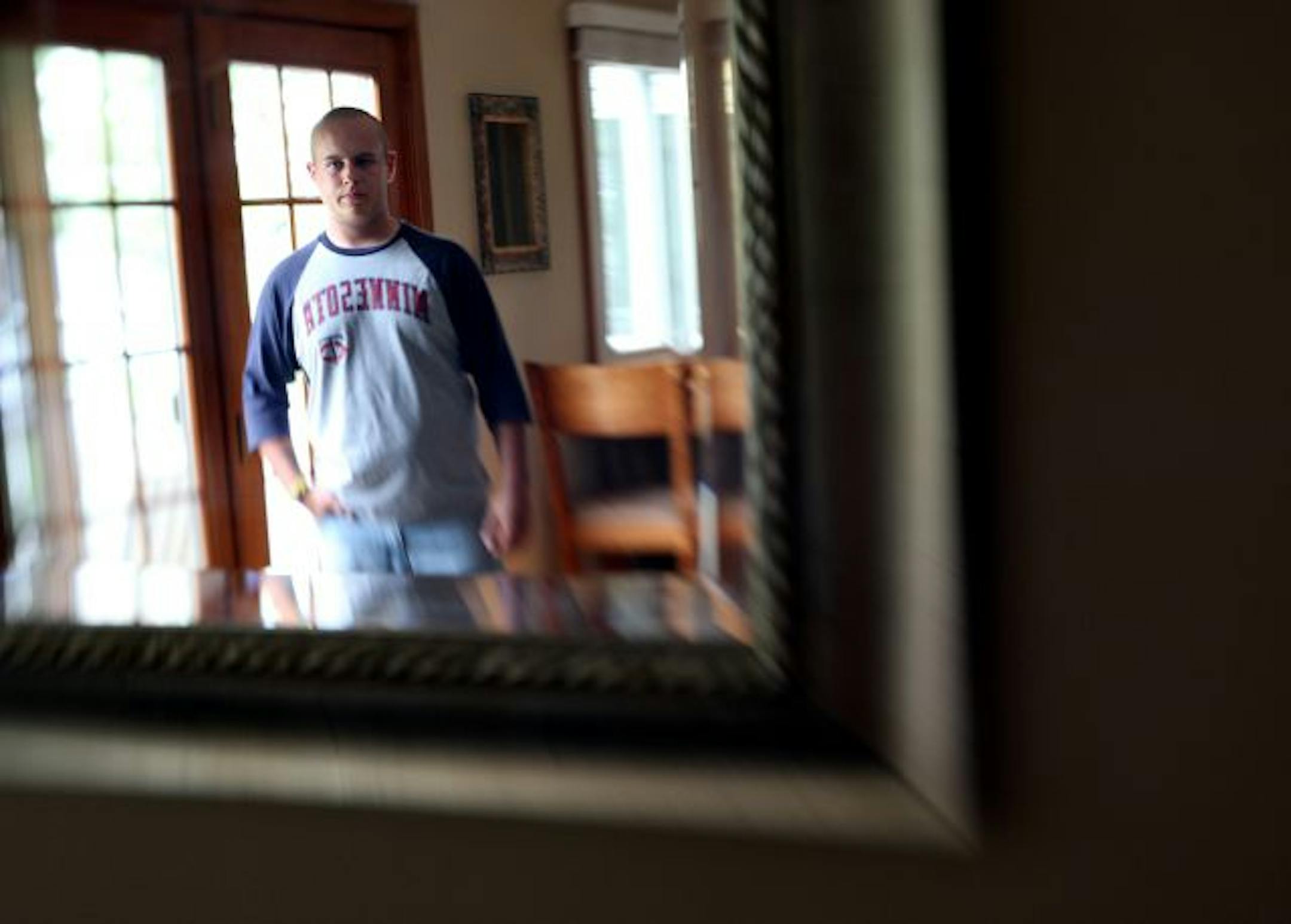 Anoka-Hennepin School District has agreed to pay a $25,000 settlement to the family of Alex Meritt (pictured) after two teachers made jokes that lead to constant teasing from peers and eventually caused him to switch schools. Meritt is photgraphed through a mirror in his home in Elk River. Meritt is going to into the Army in a couple weeks.