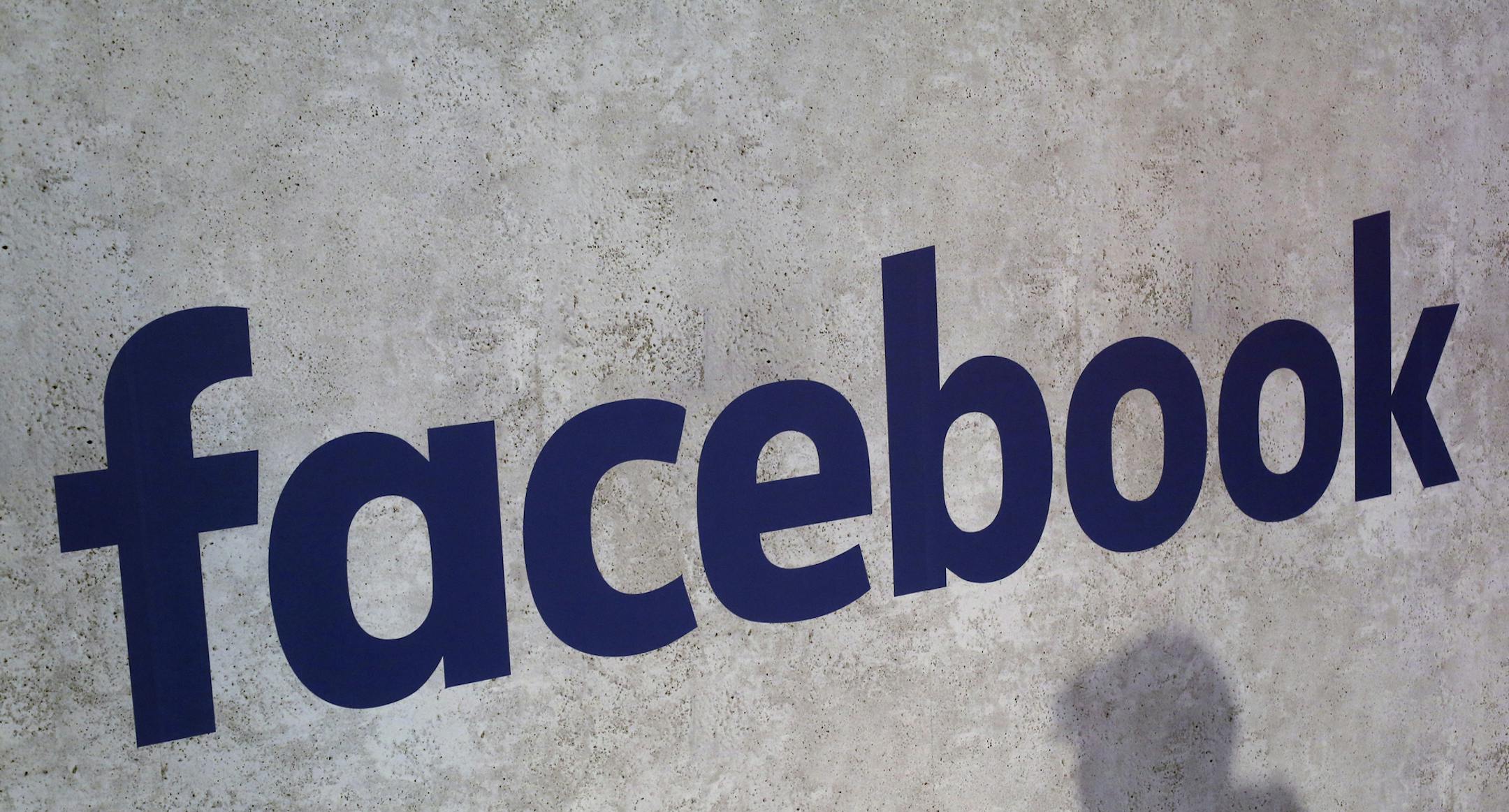 FILE - This Jan. 17, 2017, file photo shows a Facebook logo displayed in a start-up companies gathering at Paris' Station F in Paris. Facebook says it is investing $300 million over the next three years in local news programs, partnerships and other initiatives. The cash investment includes reporting grants for local newsrooms and investing in nonprofits aimed at helping support local news. (AP Photo/Thibault Camus, File)