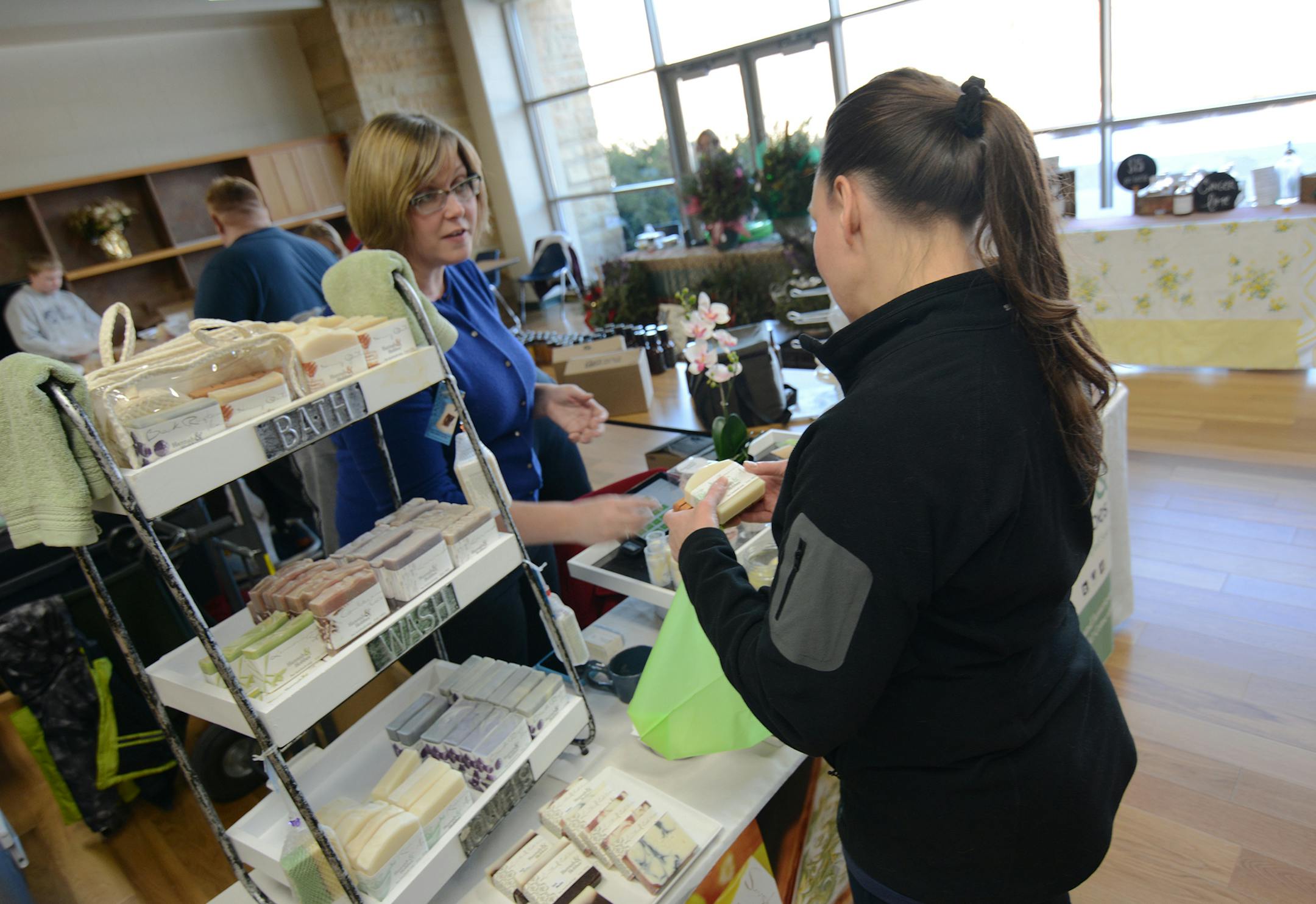 Chrissy Wheeler, of Apple Valley, tells Cheryl Renk, of Eagan, about her soaps. Photo by Liz Rolfsmeier, Special to the Star Tribune