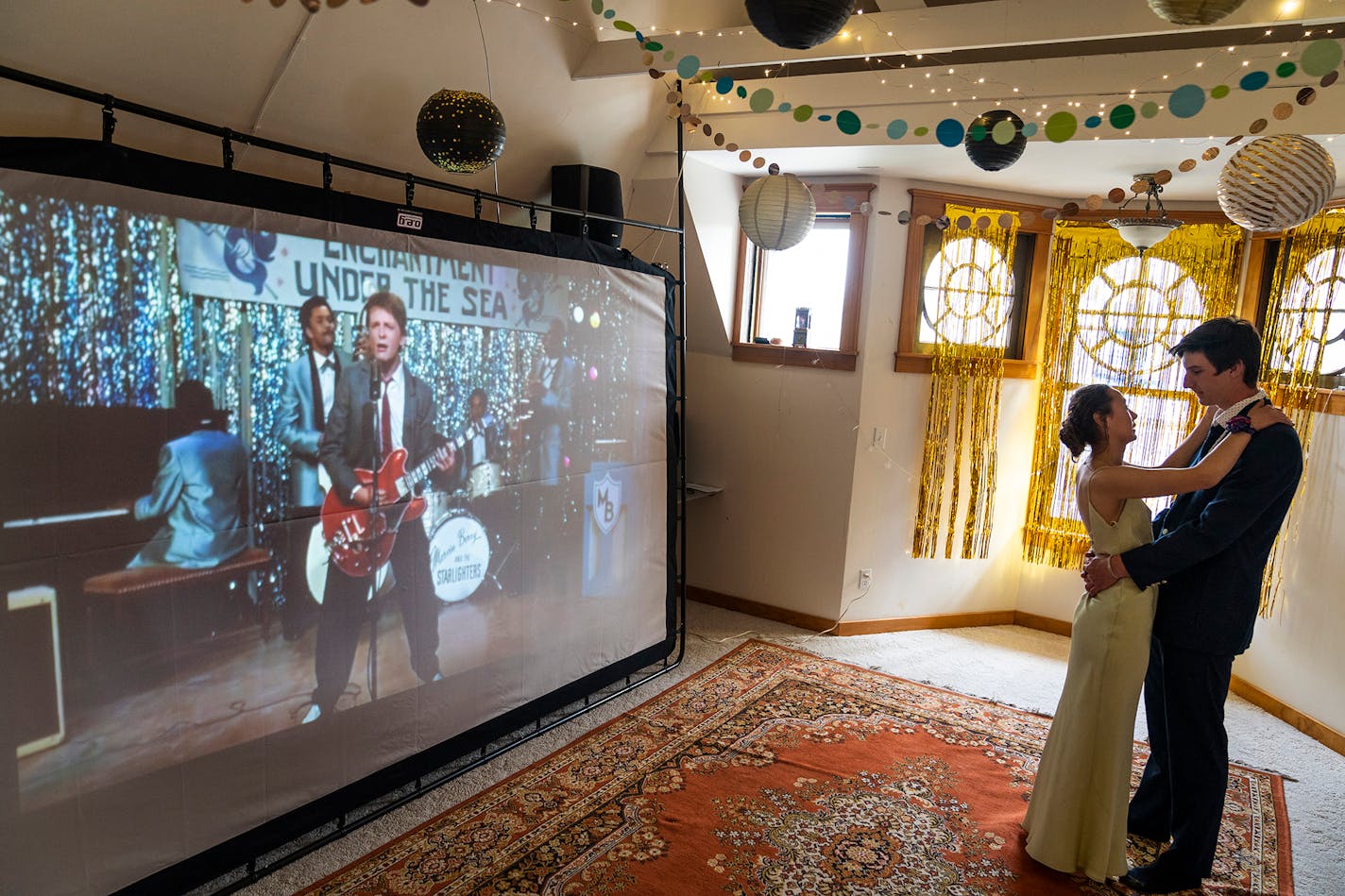 Serafina Rivera 17, a senior at Nova Classical Academy, danced with her prom date Ben Parsonage, 17, a junior, during their prom for two at Rivera's home in St. Paul as the movie "Back to the Future" played on a screen.