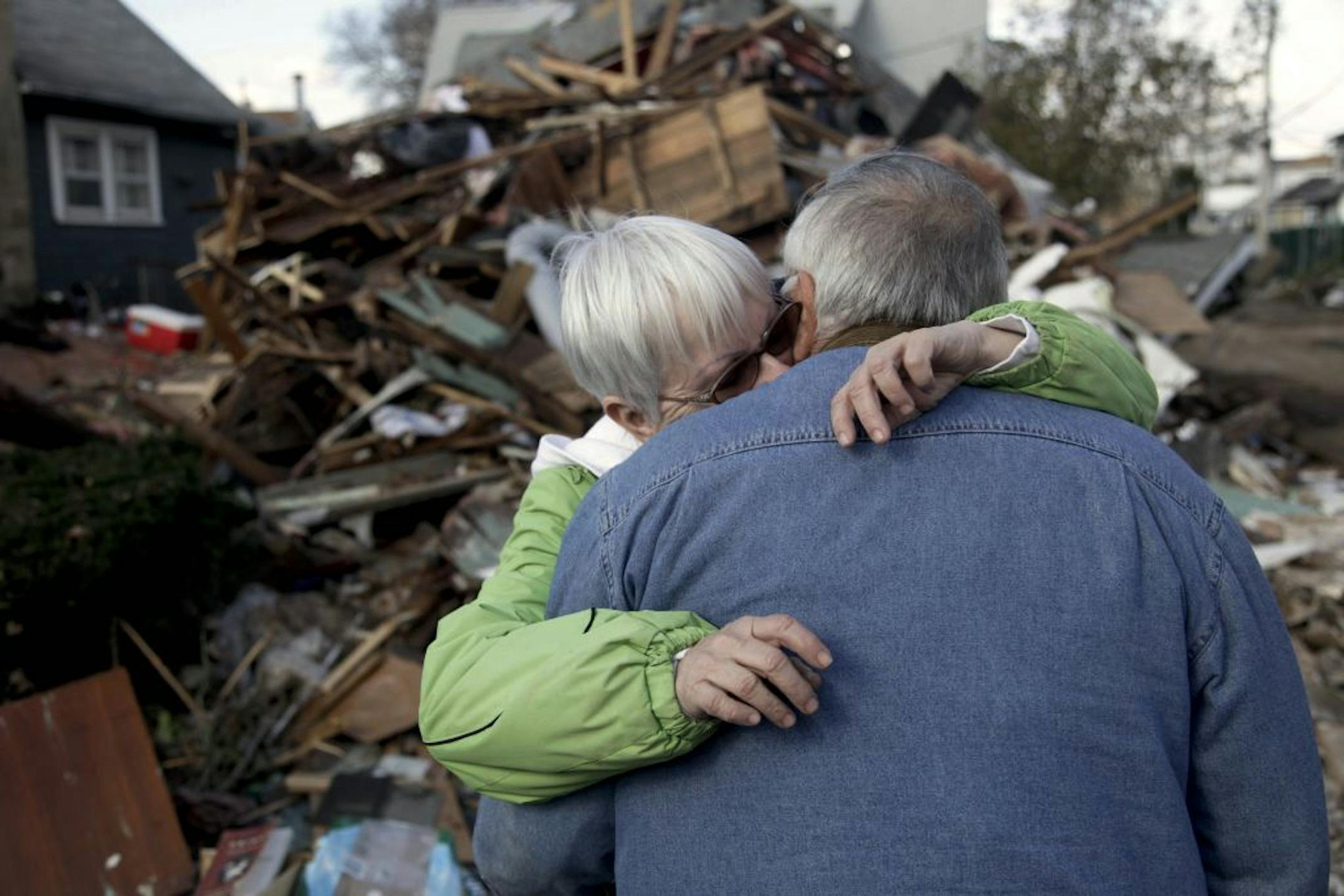 Sheila and Dominic Traina hug in front of their home which was demolished during Hurriane Sandy in Staten Island, N.Y., Friday, Nov. 2, 2012.