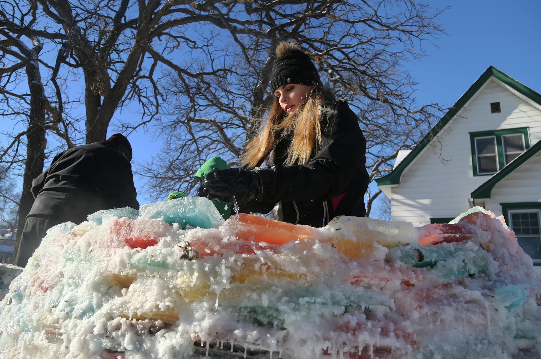 Martha Palm, her family and some former students of hers will be working on the multi-colored igloo they are building at the Palms' south Minneapolis home and seen Saturday, Dec. 30, 2017, in Minneapolis, MN. Here, Inge Marie Palm, 15, used a mixture of water and snow as a mortar to cement the ice blocks together for the igloo.