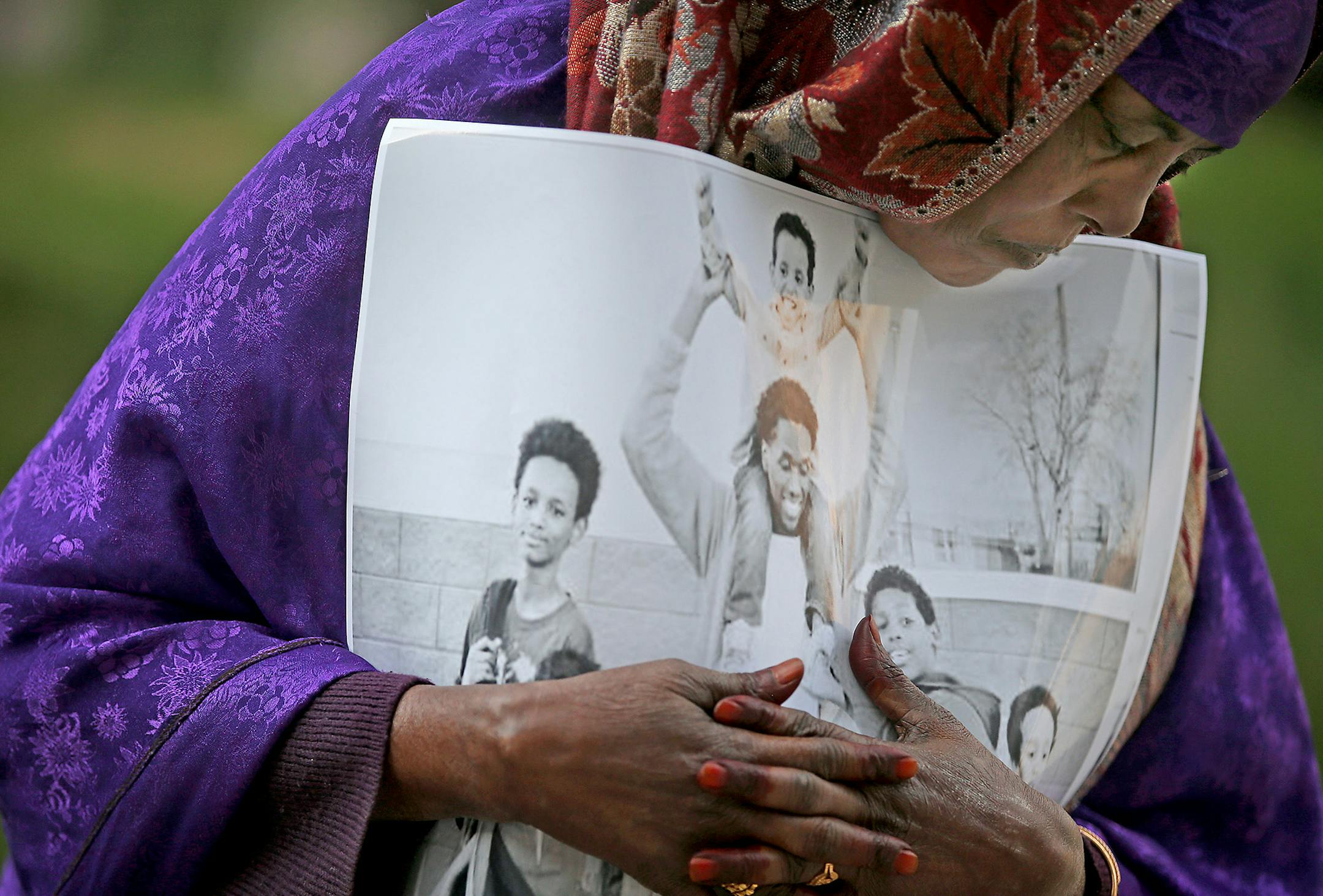Haqhawo Qaasim, cq, held onto a photo of one of the young men, Guled Ali Omar, who will stand trial during the opening day of the ISIL recruit trial, in front of the United States Courthouse, Monday, May 9, 2016 in Minneapolis, MN. ] (ELIZABETH FLORES/STAR TRIBUNE) ELIZABETH FLORES &#xef; eflores@startribune.com ORG XMIT: MIN1605090930460612