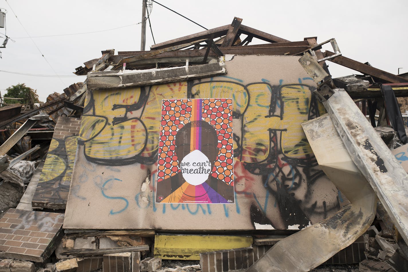 A poster reading "We Can't Breathe" is pasted to the remains of an AutoZone store in Minneapolis on June 9, 2020. The site burned on May 27 when the neighborhood surrounding the Third Police Precinct Station became the flashpoint for protests and demonstrations after the killing of George Floyd on May 25. (Stephen Maturen/Getty Images/TNS) ORG XMIT: 1727856