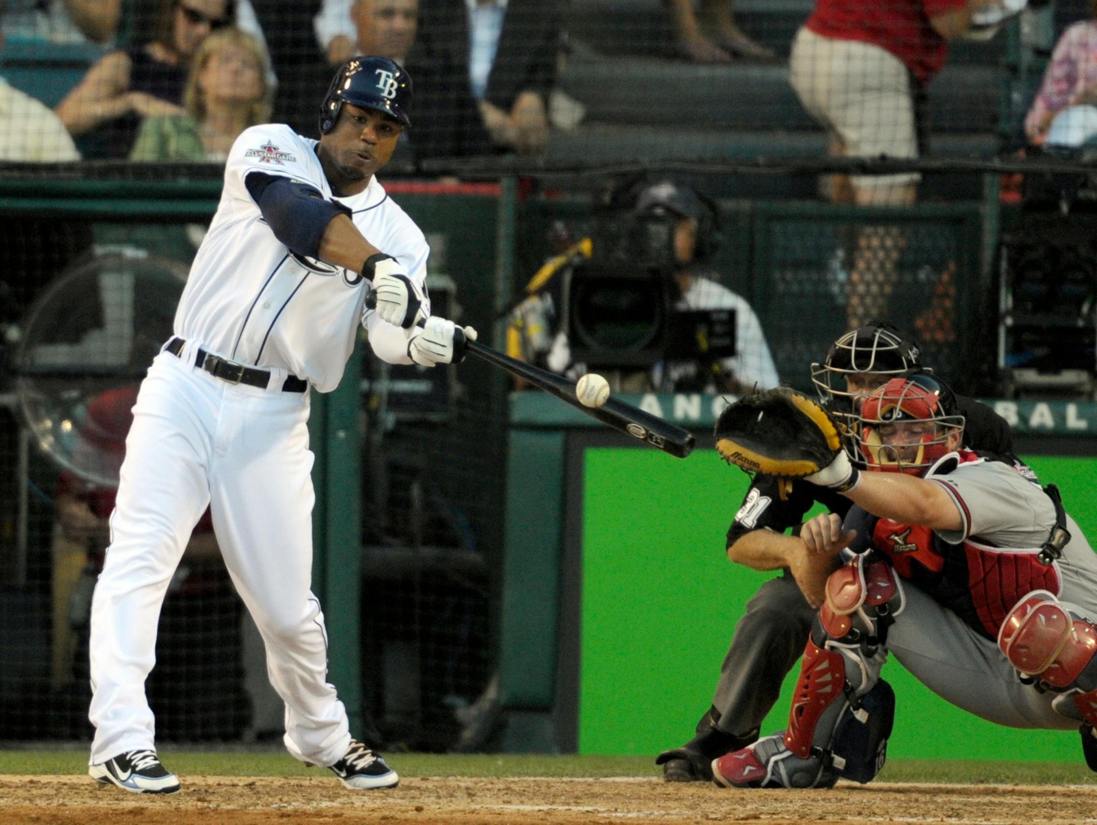 The American League's Carl Crawford, of the Tampa Bay Rays, hits into a fielder's choice during the fifth inning of the All-Star baseball game Tuesday, July 13, 2010, in Anaheim, Calif. National League catcher Brian McCann, of the Atlanta Braves, is at right.
