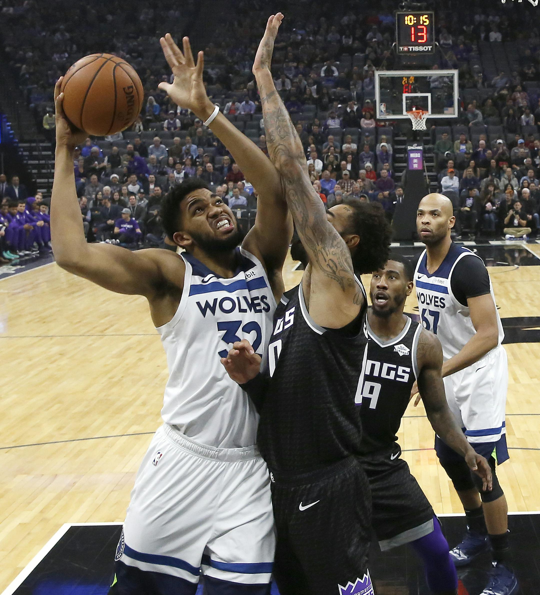 Minnesota Timberwolves center Karl-Anthony Towns, left, goes to the basket against Sacramento Kings center Willie Cauley-Stein during the first quarter of an NBA basketball game, Wednesday, Dec. 12, 2018, in Sacramento, Calif. (AP Photo/Rich Pedroncelli)