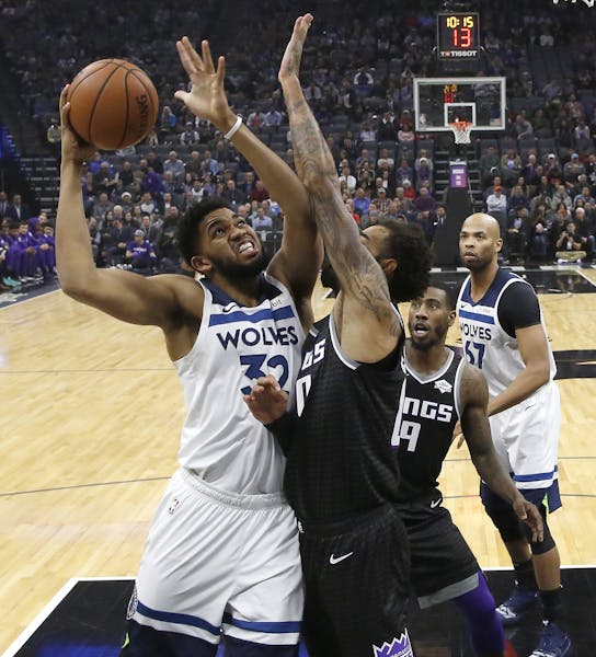 Minnesota Timberwolves center Karl-Anthony Towns, left, goes to the basket against Sacramento Kings center Willie Cauley-Stein during the first quarte