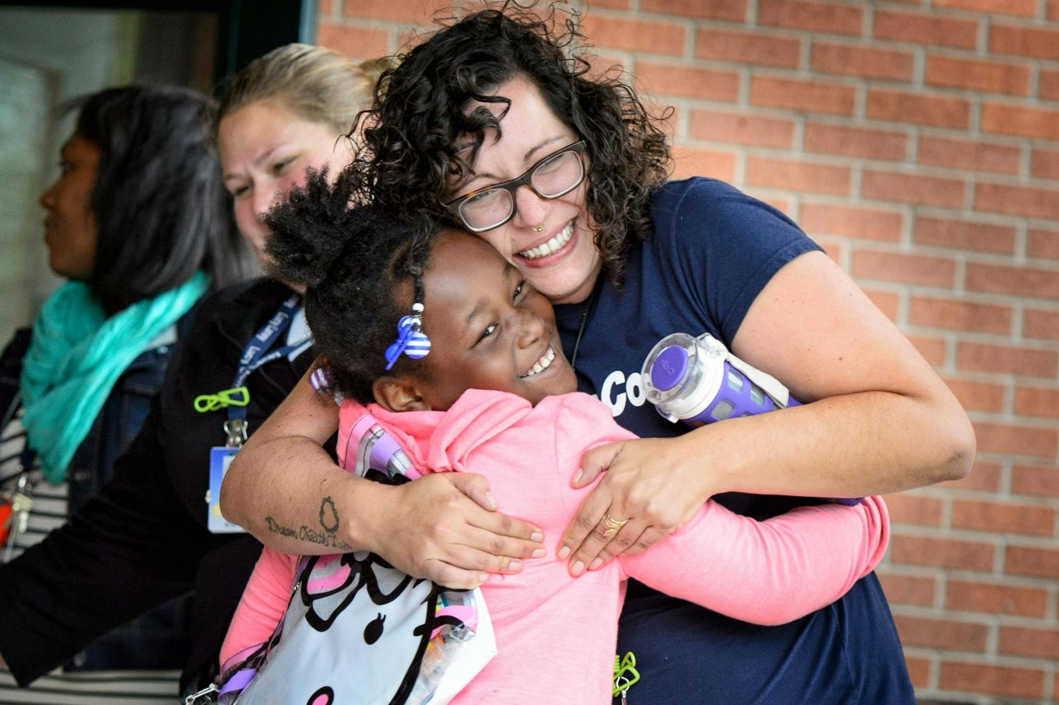 Kindergarten teacher Sadie Fitzgerald greeted former student, now first grader Raykia Harris with a big hug as she returned to Lucy Laney Elementary School for the first day of school.