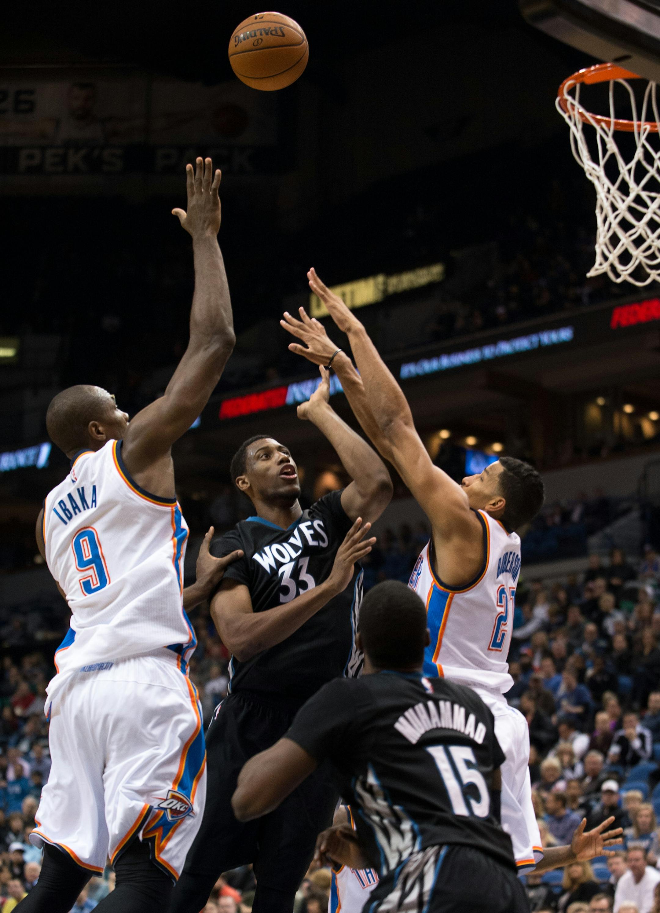 Minnesota Timberwolves forward Thaddeus Young (33) shoots and hits a tear drop shot between Oklahoma City Thunder forward Serge Ibaka (9) and guard Andre Roberson (21) during the second quarter. ] AARON LAVINSKY • aaron.lavinsky@startribune.com The Minnesota Timberwolves take on the Oklahoma City Thunder Friday, Dec. 12, 2014 at Target Center in Minneapolis, Minn.