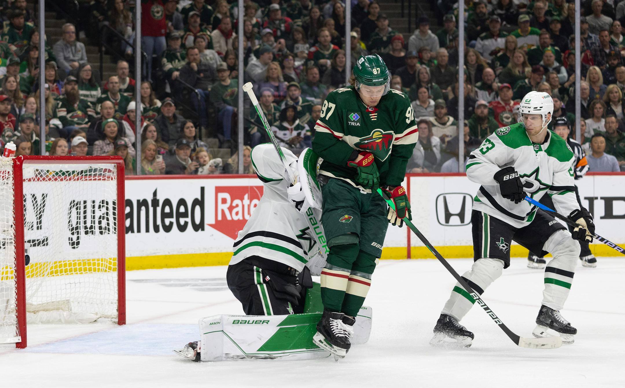 Minnesota Wild left wing Kirill Kaprizov (97) screened Dallas Stars goaltender Jake Oettinger (29) in the first period while as Dallas Stars defenseman Esa Lindell (23) looked on.